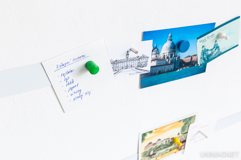 Poznámky a pohlednice na pokovené pásce na zdi.