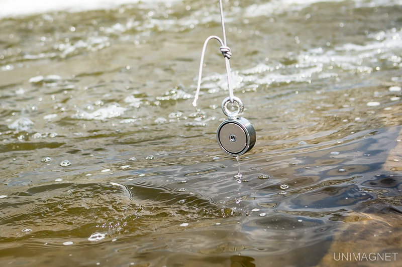 Magnet fishing u řeky pod jezem.