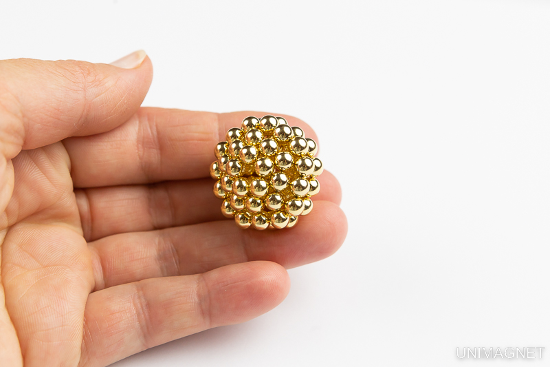 Zlaté magnetické kuličky v dlani